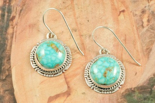 Genuine High Grade Kingman Web Turquoise set in Sterling Silver Earrings. Created by Navajo Artist Lucy Valencia. Signed L. J. by the artist. The Mineral Park Mine, in the Cerbat Mountains 14 miles northwest of Kingman, was first mined by Indians centuries before white man came to the area. It is one of the three sites of prehistoric mining localities in the state of Arizona. Mineral Park was the most extensively worked area by the Indians of the three. S.A. �Chuck� Colbaugh found a cache of stone hammers uncovered in ancient trenches and tunnels, when he had the turquoise mining concession in May of 1962. Ithaca Peak and Turquoise Mine (formally called Aztec Mountain or Aztec Peak) are the most famous of the peaks in the area containing turquoise.